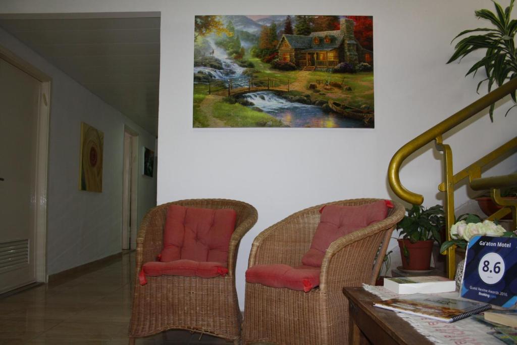 納哈里亞的住宿－嘉騰汽車旅館，墙上画画的房间里,有两把椅子