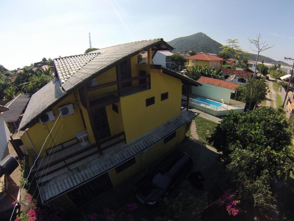 an overhead view of a yellow house with a swimming pool at Pousada Manicaca in Guarda do Embaú