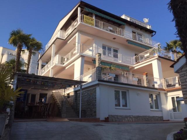 Un grand bâtiment blanc avec un balcon est à votre disposition. dans l'établissement Apartmani Villa Christina, à Ičići