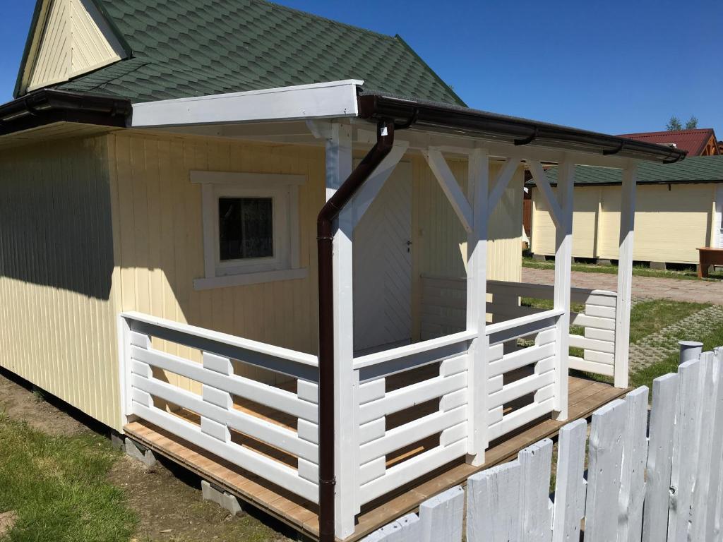 a white fence in front of a house at Domki Abiga in Sianozety