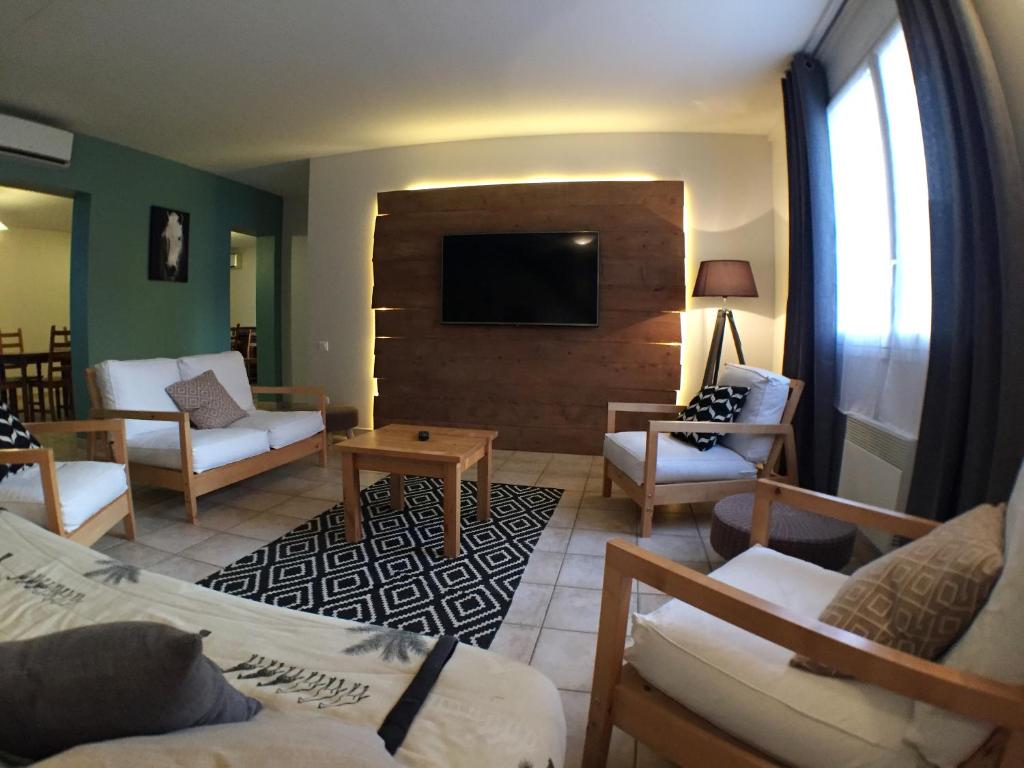 a living room with couches and a flat screen tv at Domaine de la Loge in Flacey-en-Bresse