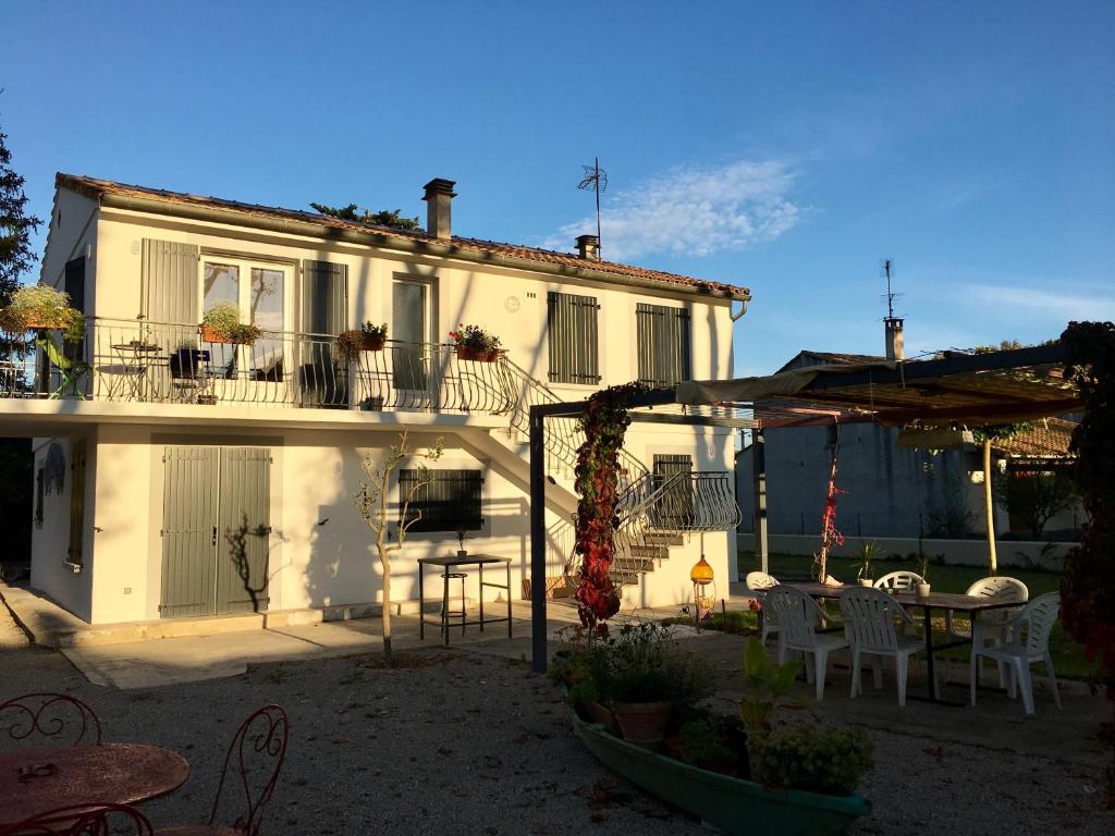 ein Haus mit einer Terrasse mit einem Tisch und Stühlen in der Unterkunft Chez marinette in Le Cailar