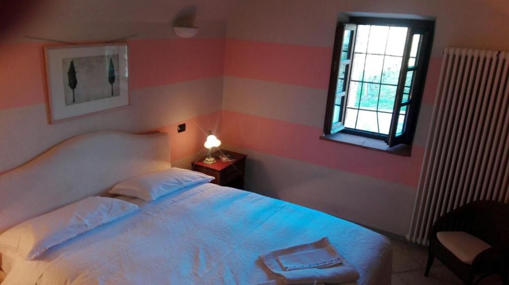 - une chambre avec un lit blanc et une fenêtre dans l'établissement Archisa Relais Hostaria, à Farigliano