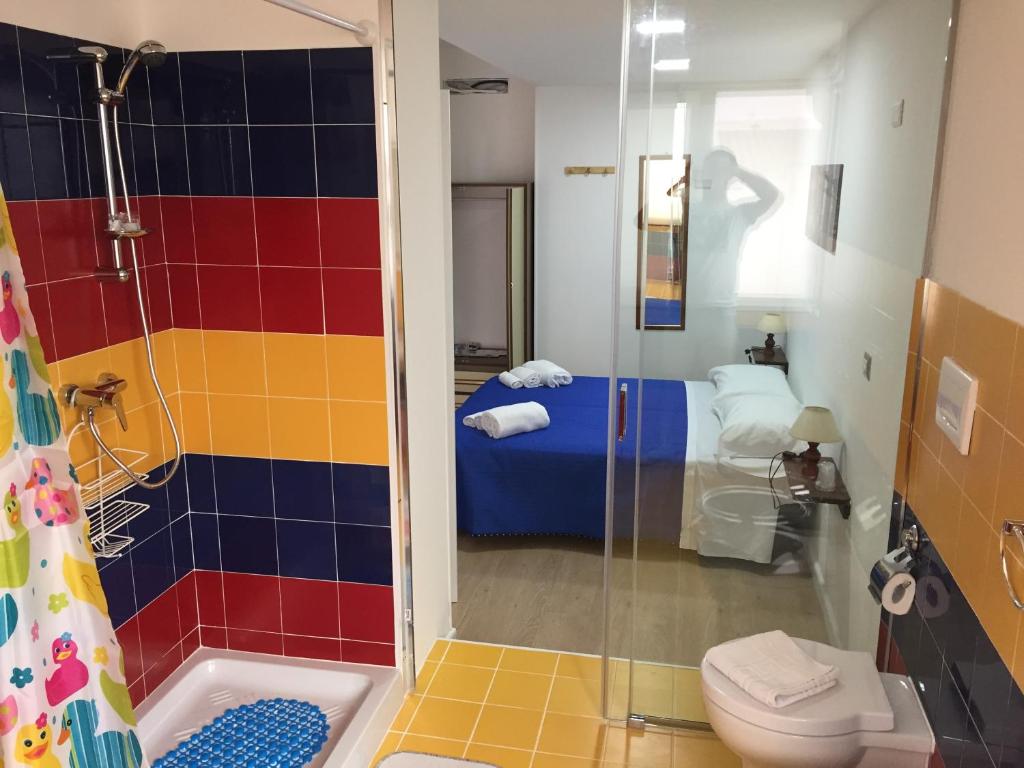 uma casa de banho com um chuveiro, um WC e uma cama em Bed & Breakfast Chloe Tropea em Santa Domenica