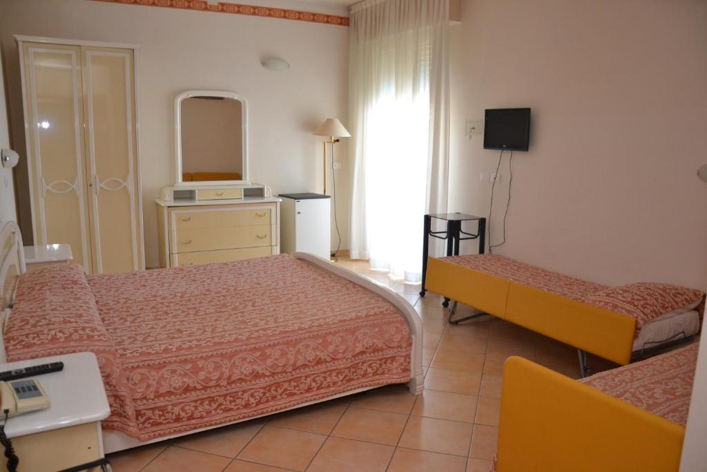 Pokój hotelowy z 2 łóżkami i lustrem w obiekcie Perticari w mieście Pesaro
