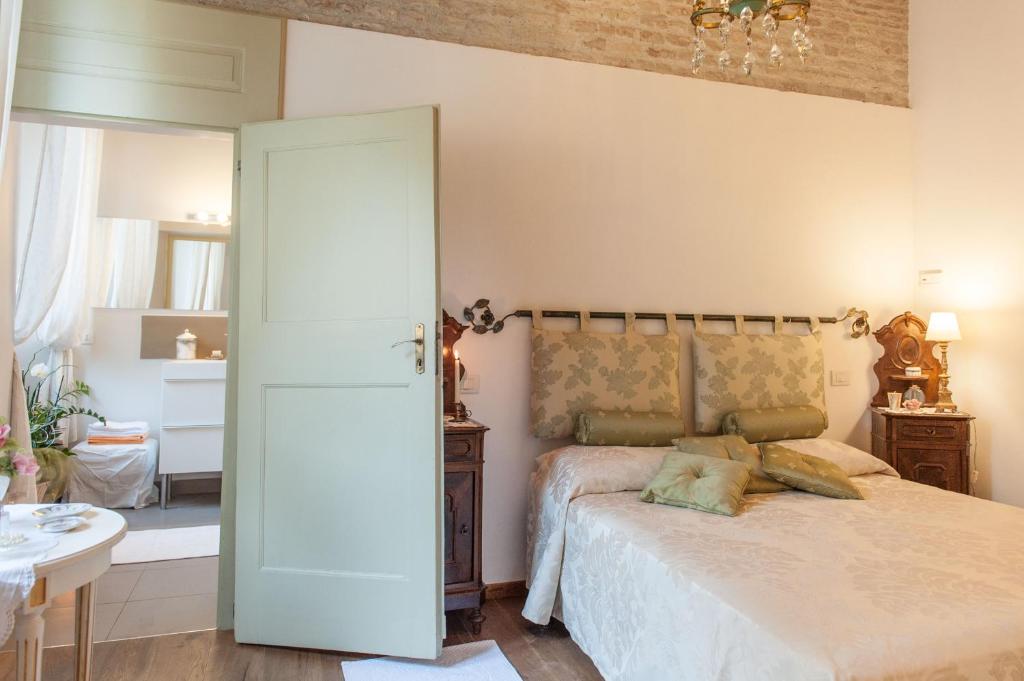 a bedroom with a bed and a chandelier at Borgo dei Salinari Apartments in Cervia