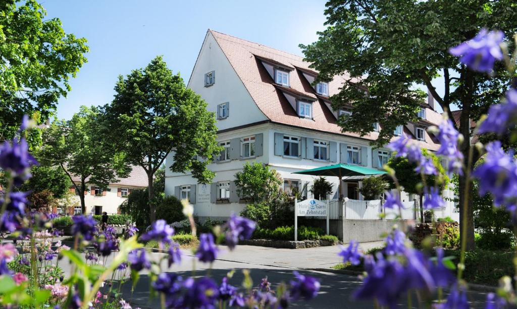 ein Haus mit lila Blumen davor in der Unterkunft Am Zehntstadl Hotel & Sauna in Ulm