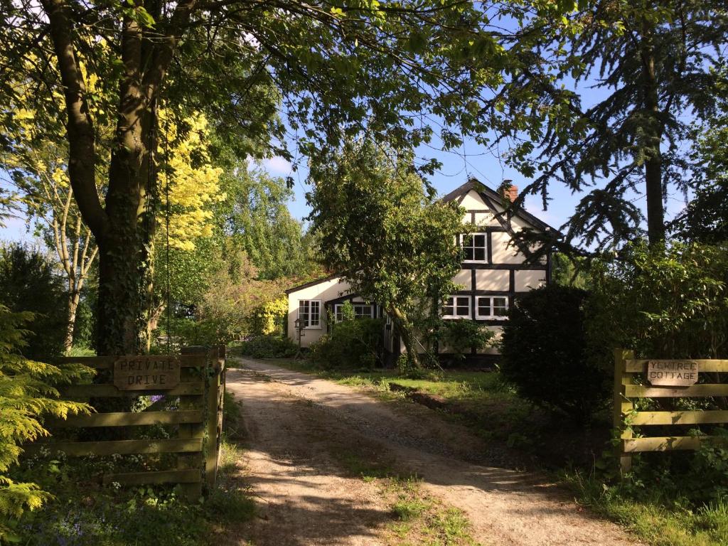 een wit huis met een hek ervoor bij Yew Tree Cottage in Leominster