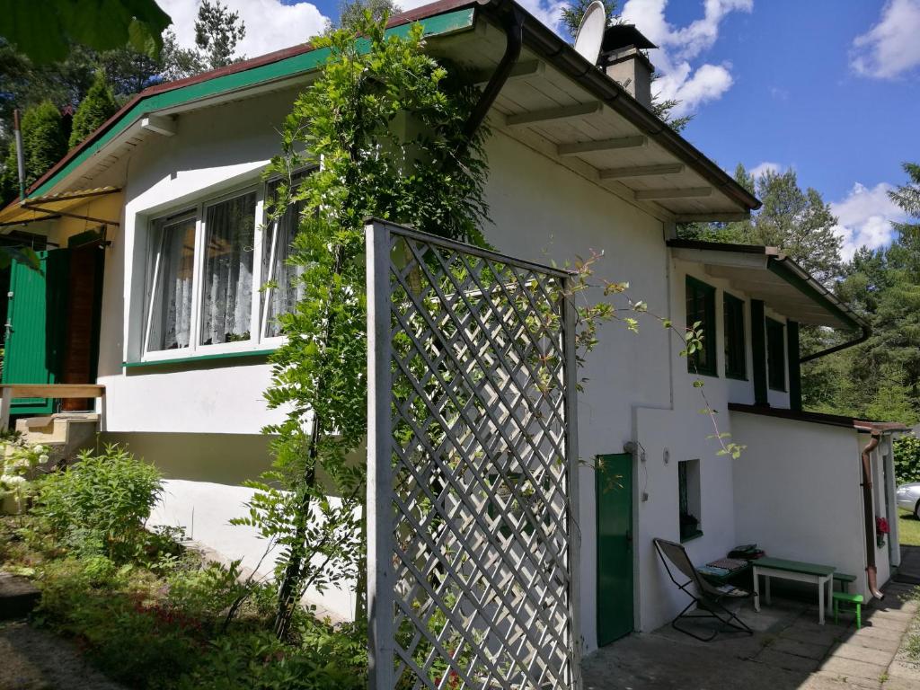 ein weißes Haus mit einem Tor davor in der Unterkunft Domek Schodno in Schodno