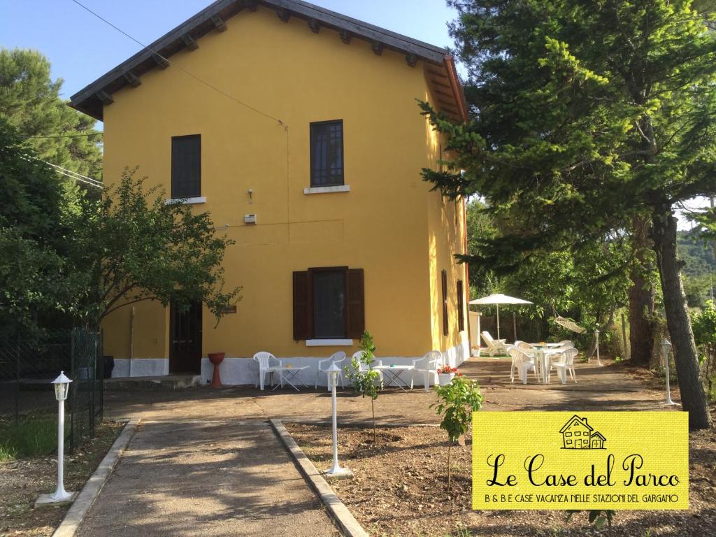 een geel huis met een bord ervoor bij Le Case del Parco in Peschici