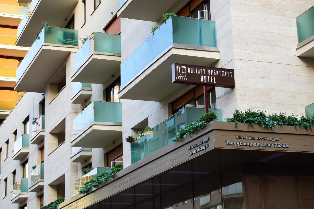 un edificio de apartamentos con plantas en los balcones en Corvin holiday Apartments hotel en Budapest
