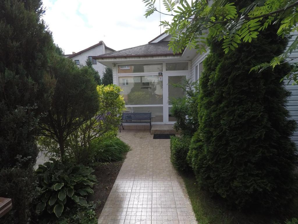 a walkway leading to a house with a bench at Jednorodzinny Dom Westchnień w Dziwnowie in Dziwnów