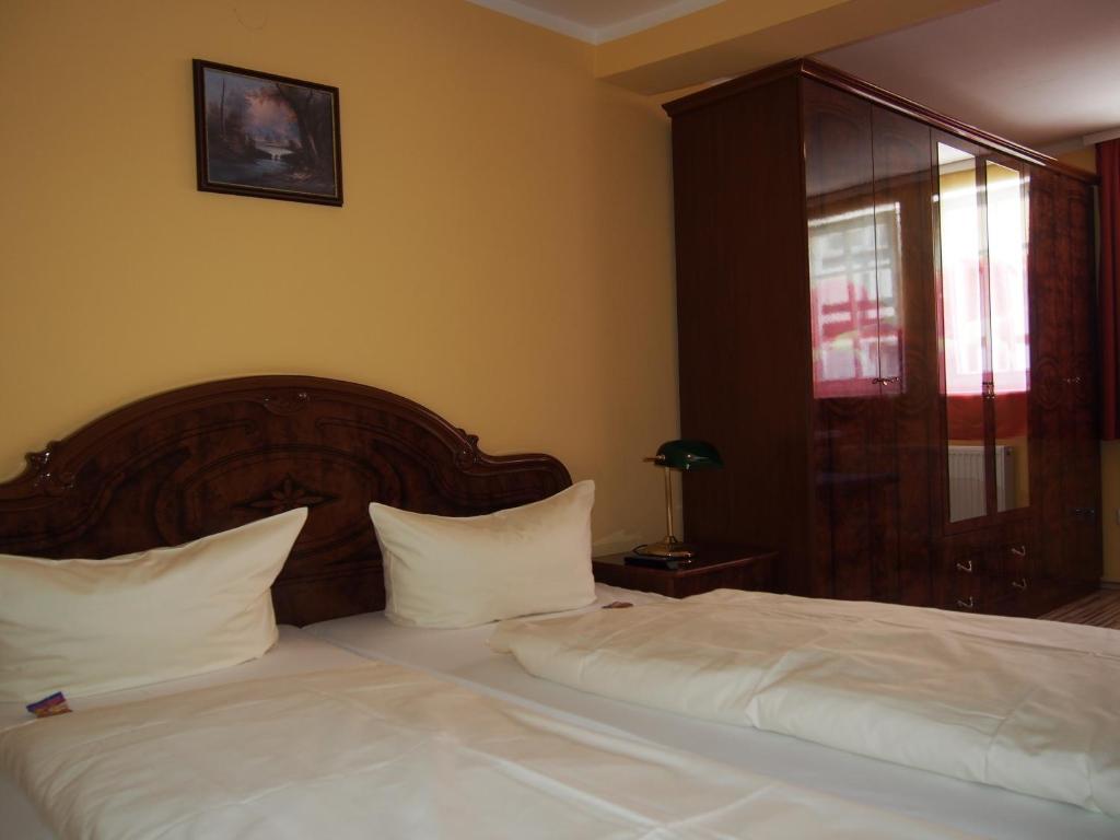 Schlafzimmer mit einem Bett mit weißer Bettwäsche und einem Fenster in der Unterkunft Hotel Restaurant LR6 in Bad Sooden-Allendorf