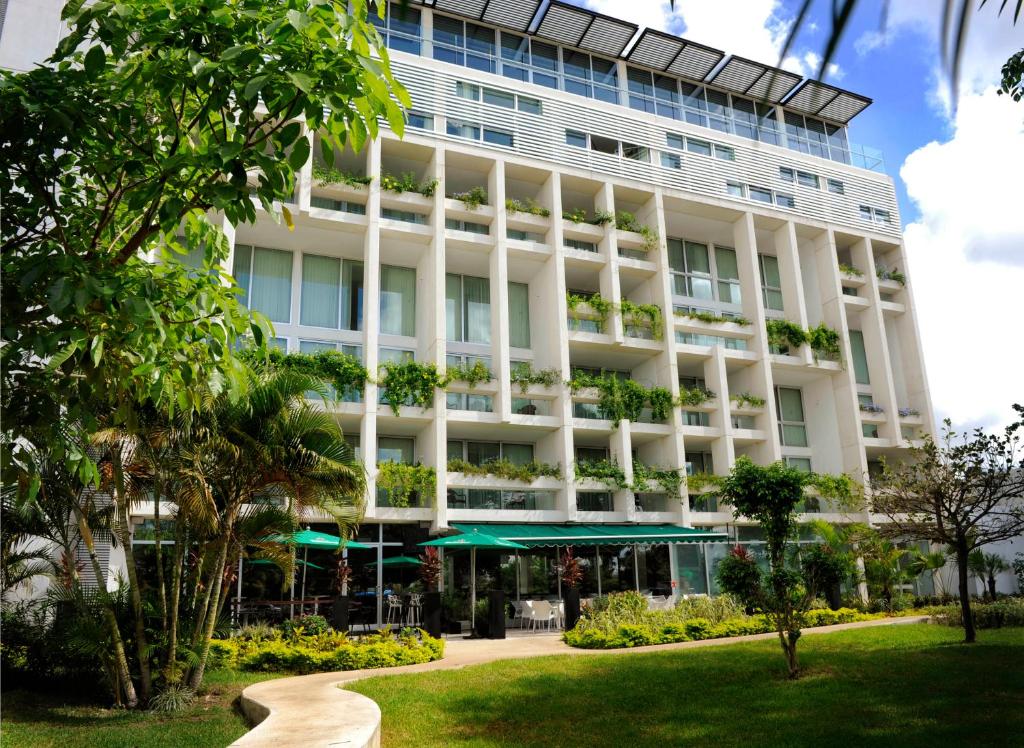 a large white building with a garden in front of it at Mesón de la Luna Hotel & Spa in Mérida