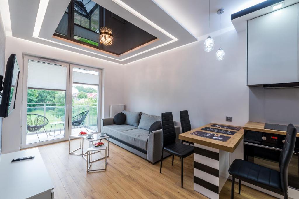 a living room with a couch and a table at Apartament Marina Przy Porcie Nad Niegocinem in Giżycko