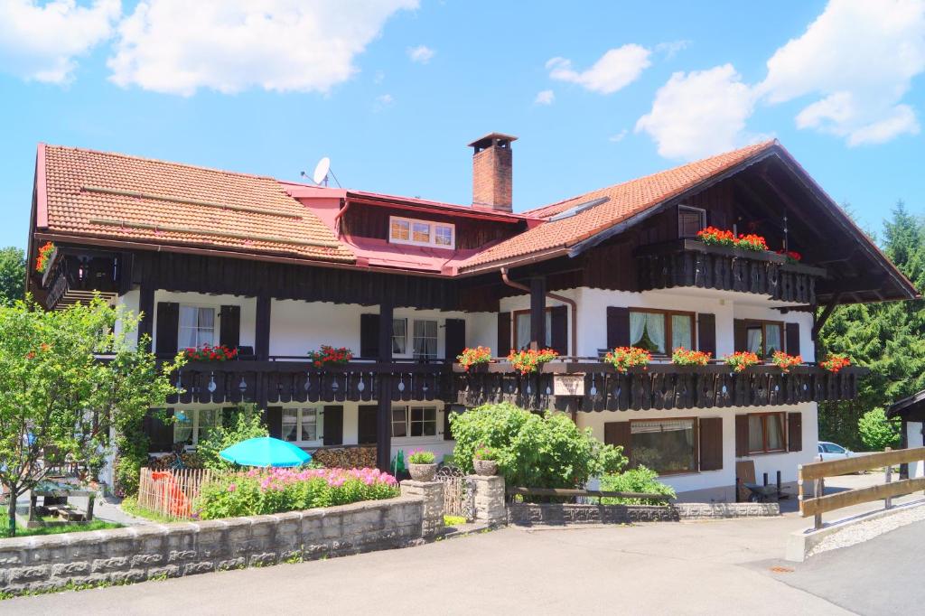 une maison avec des boîtes de fleurs sur les balcons dans l'établissement Gästehaus Greiter - Sommer Bergbahnen inklusive, à Oberstdorf