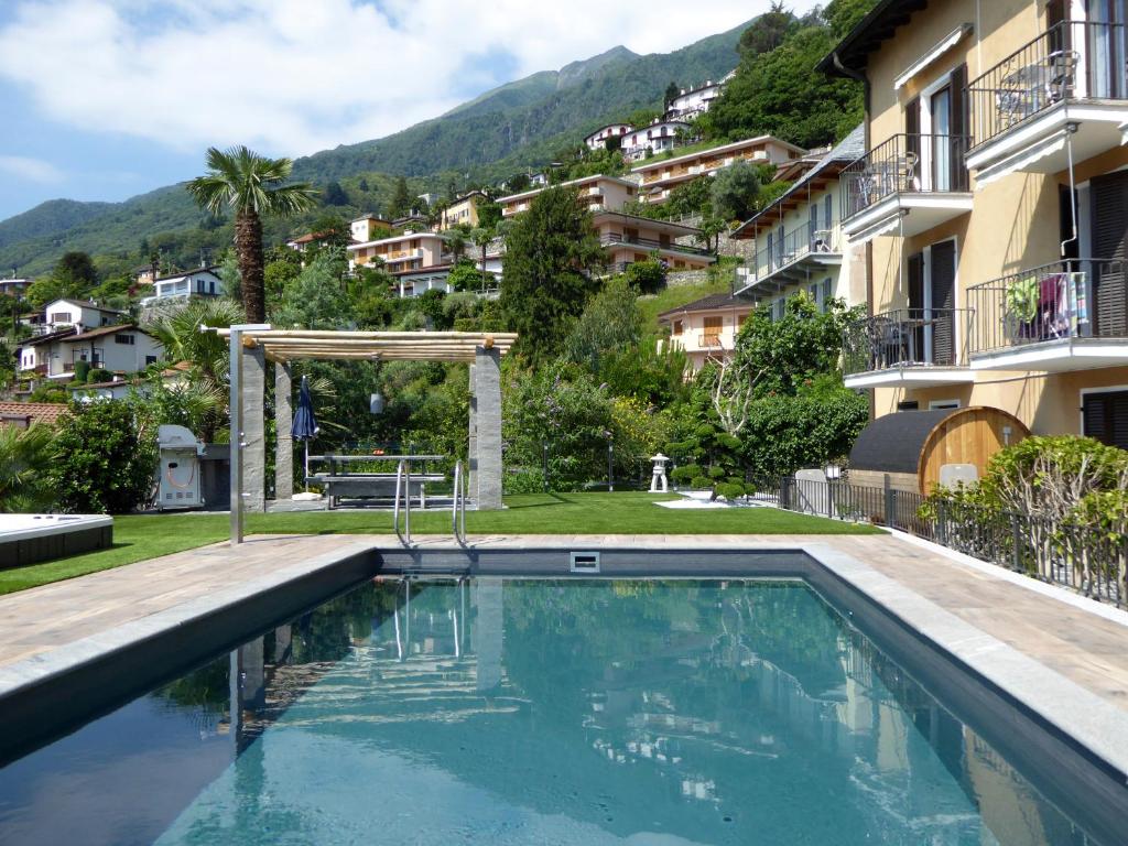 a swimming pool in front of a building at Apartments Casa Ghiggi in Brissago