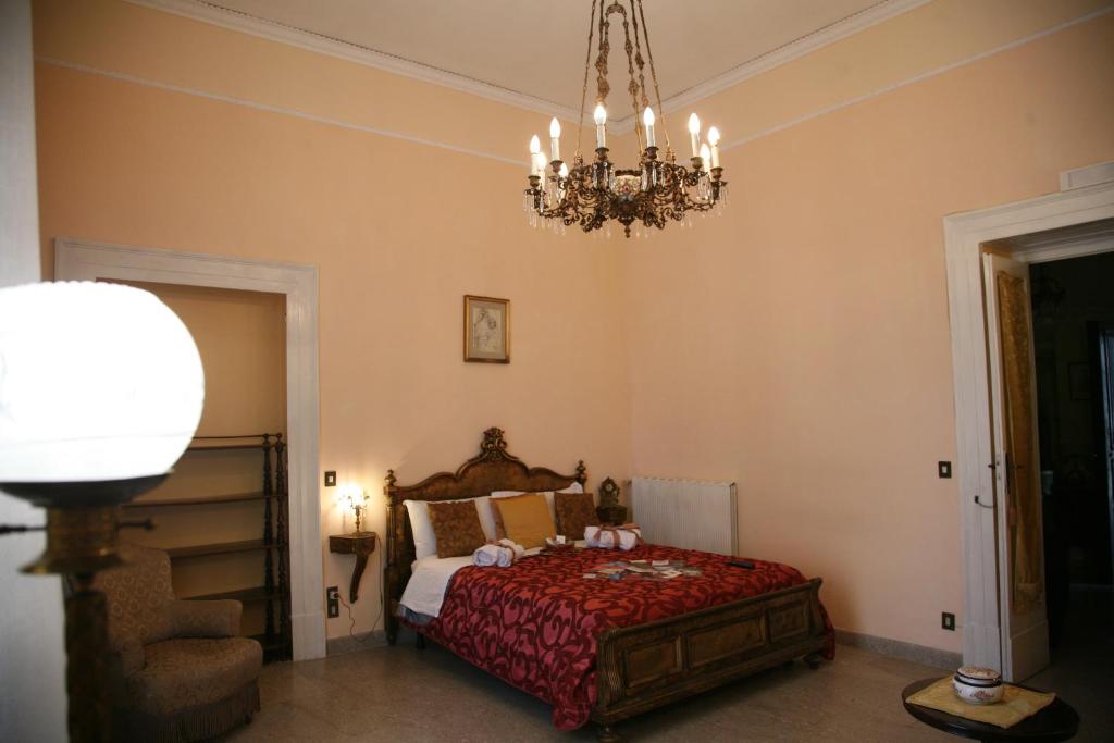 1 dormitorio con cama y lámpara de araña en Napoli Retro, en Nápoles