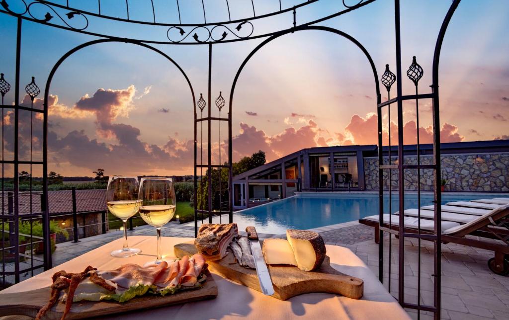een villa met een zwembad en een tafel met wijnglazen bij Agriturismo Valle del Marta in Tarquinia