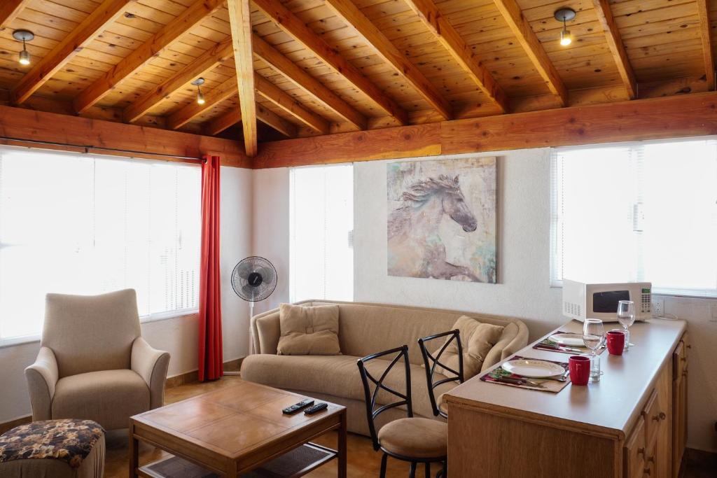 a living room with a couch and a table at Little Nest en Rancho El Rossinyol in Valle de Guadalupe