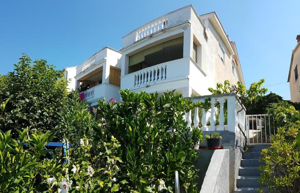 una casa blanca con escaleras y plantas en Apartments Brčić, en Sveti Petar