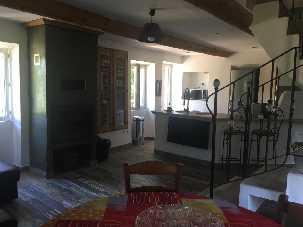 a living room with a table and chairs and a kitchen at Le Mas Sylva in La Barriére