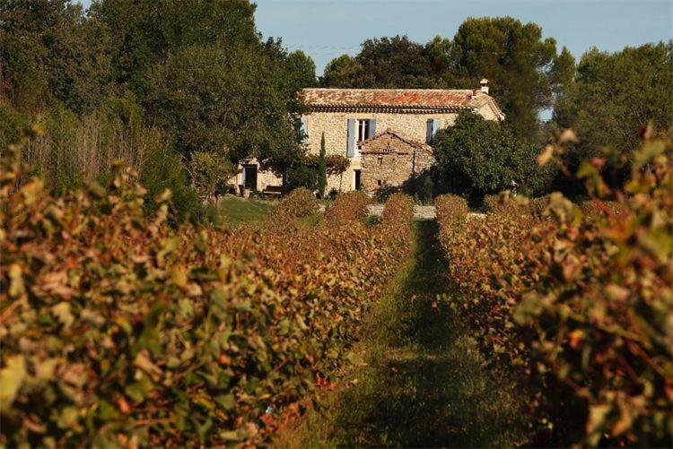 una casa en medio de un campo con un edificio en Mas d'Alphonse en Aigremont