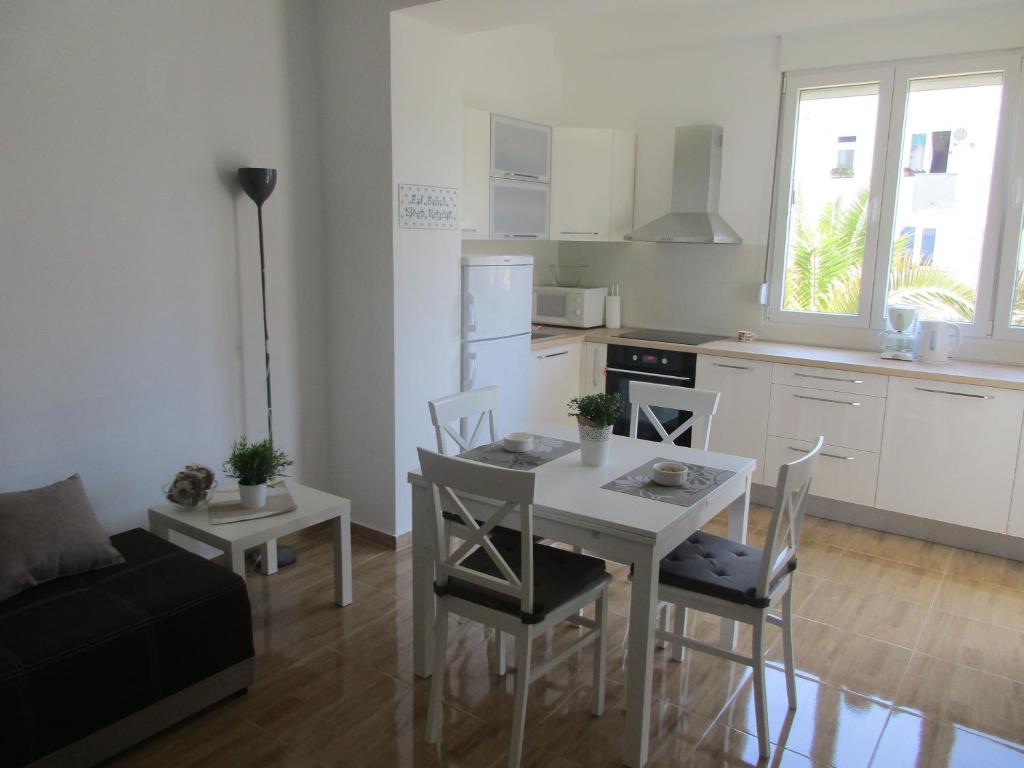 a living room with a table and chairs and a kitchen at Summer apartment in Bar