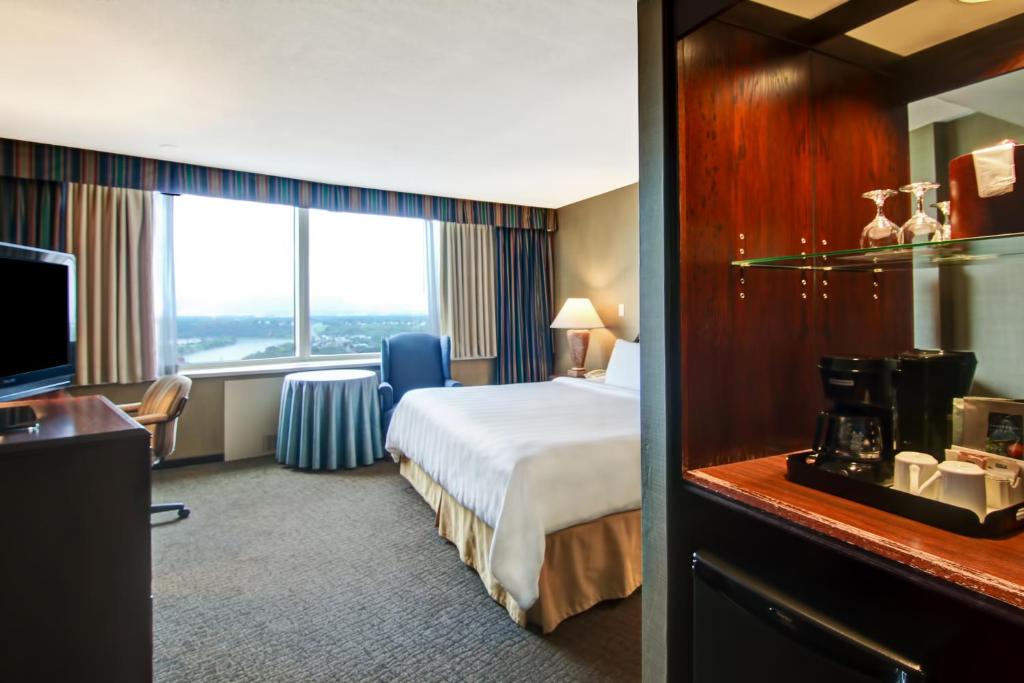 a hotel room with a bed and a large window at Chateau Lacombe Hotel in Edmonton
