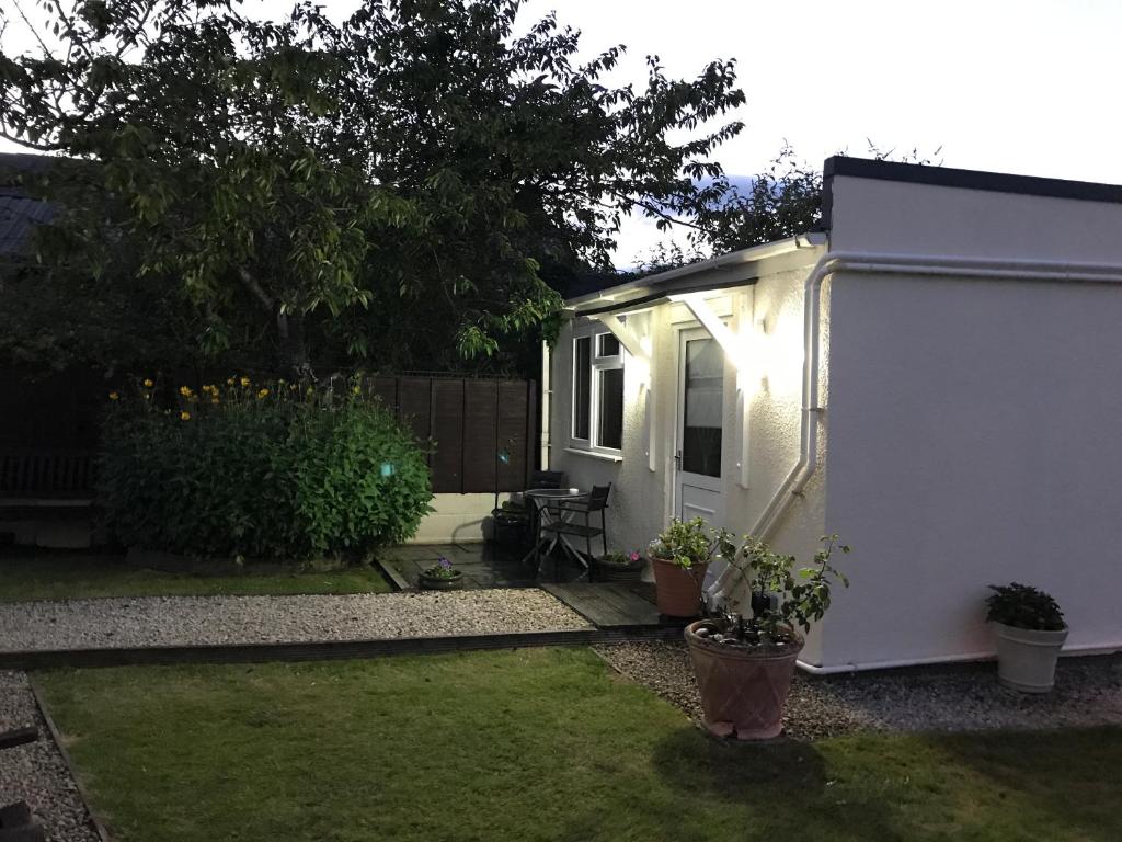 un pequeño cobertizo blanco con una mesa y una silla en The Engine Shed, en Weston-super-Mare