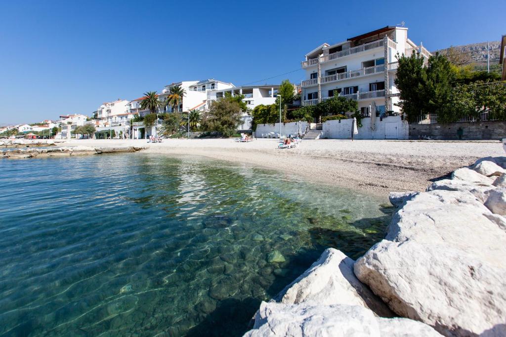 a beach with rocks in the water and buildings at Apartments Marin in Podstrana