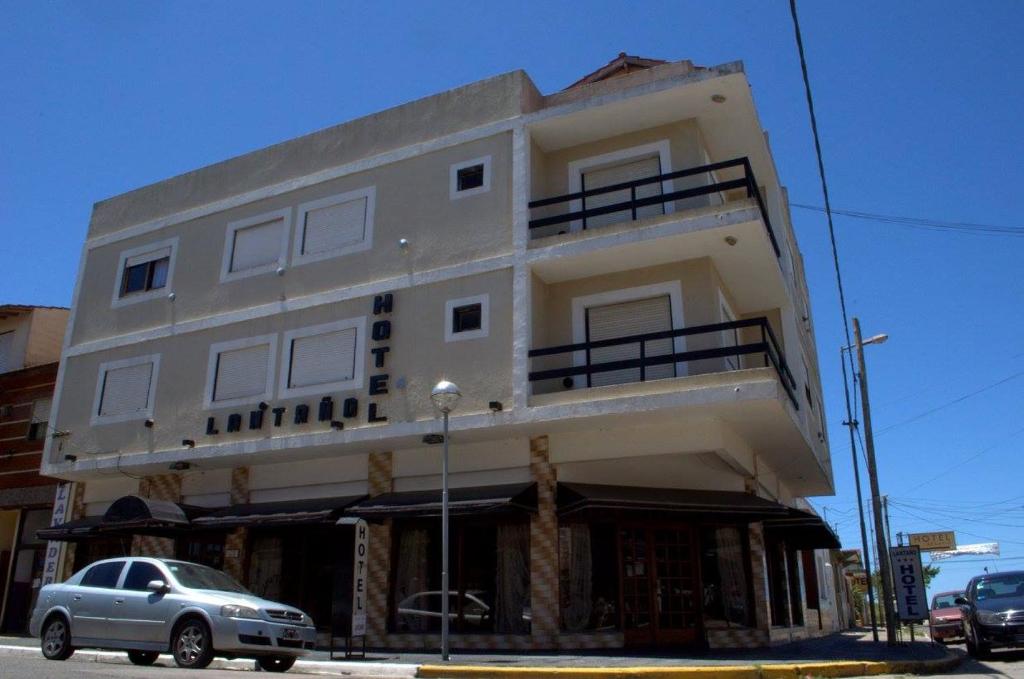 a building with a car parked in front of it at Hotel Lantaño in Mar de Ajó