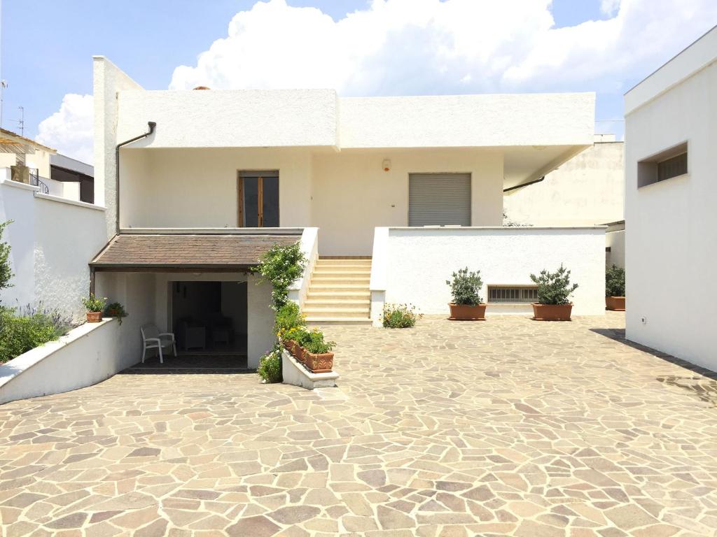 uma casa com um pátio de pedra em frente em Casapescoluse em Marina di Pescoluse