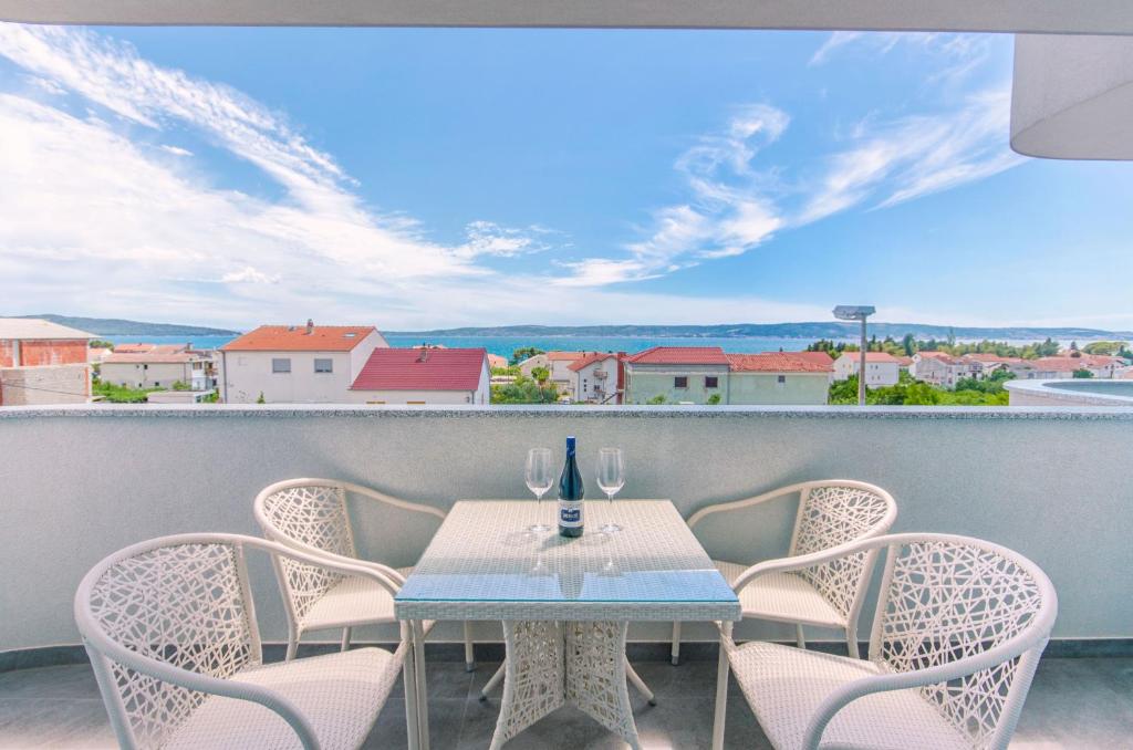 a table and chairs on a balcony with a view at Radic apartments in Kaštela