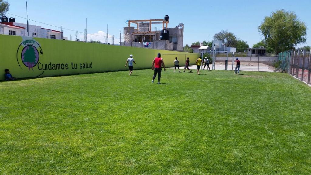 een groep mensen die voetballen op een veld bij Hotel Cipreses in Ixmiquilpan
