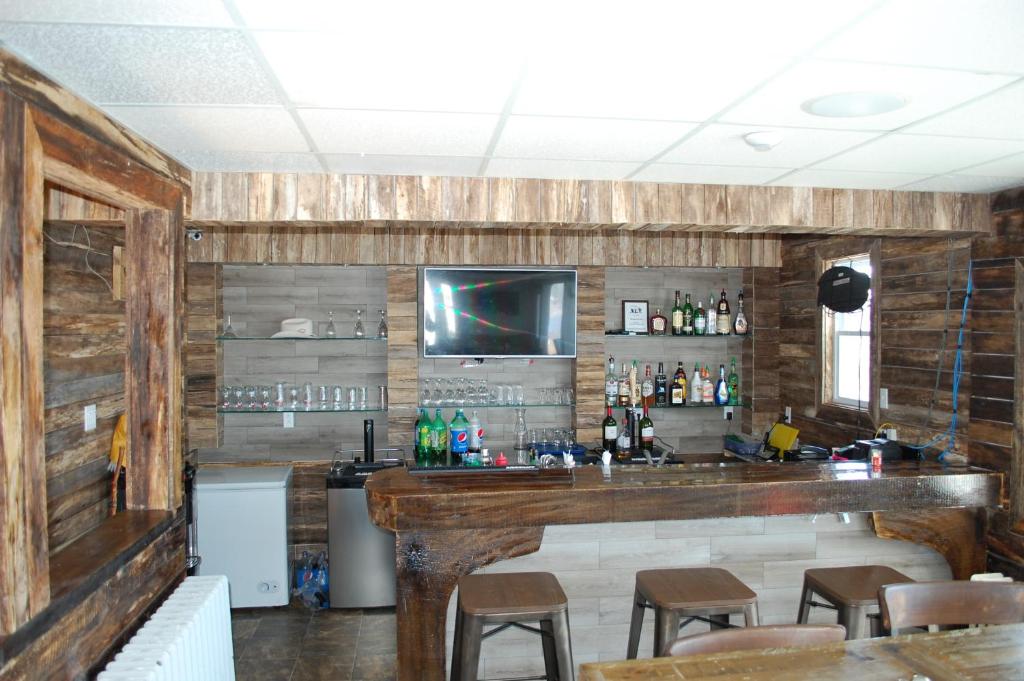 a bar in a restaurant with wooden walls at Edge of the Avalon Inn in Trepassey