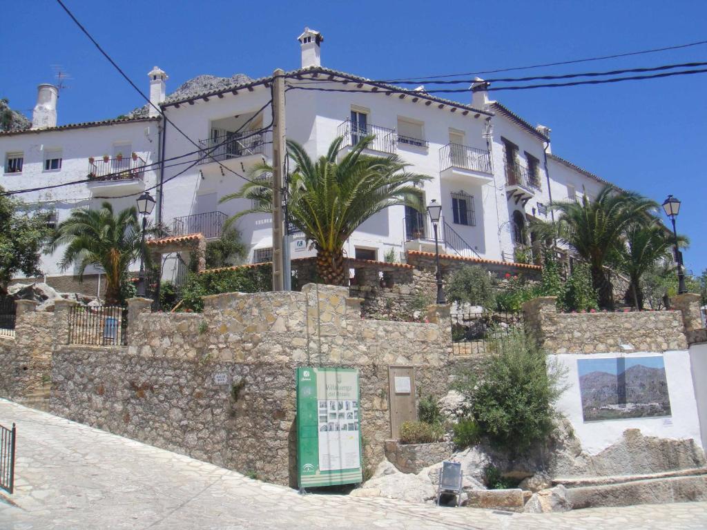 a white building on top of a stone wall at Apartamentos Buganvilla in Villaluenga del Rosario