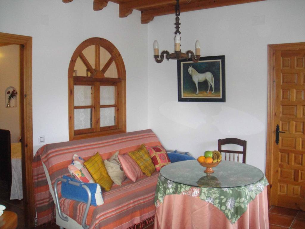 a living room with a couch and a table at Apartamentos Buganvilla in Villaluenga del Rosario