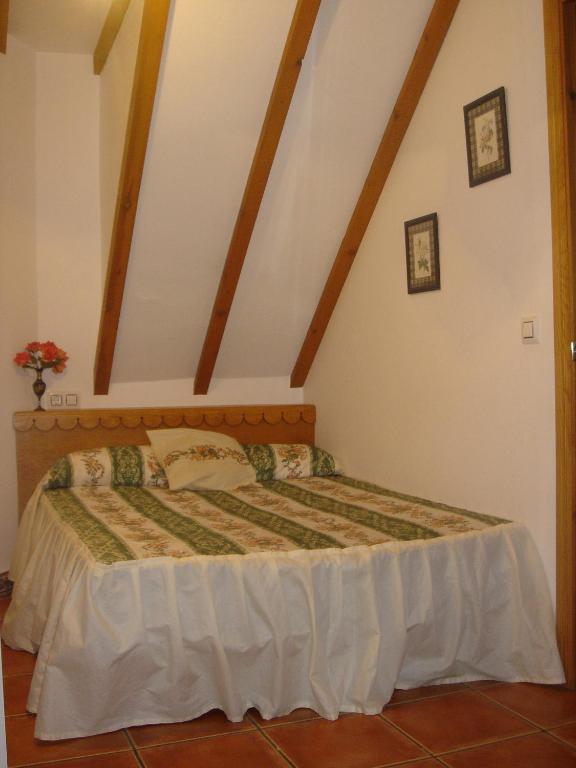 a bedroom with a bed in a attic at Apartamentos Buganvilla in Villaluenga del Rosario