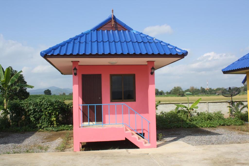 uma pequena casa rosa com um telhado azul em Panna Kalong em Wiang Chiang Khong