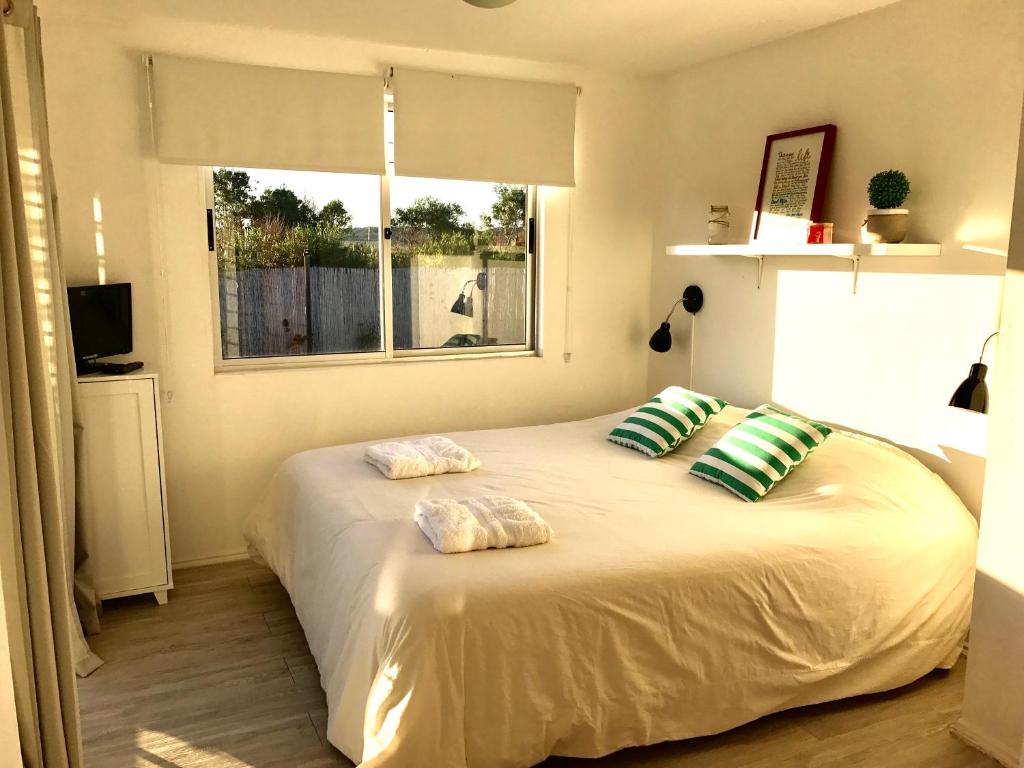 a bedroom with a large white bed with two pillows at Mahalo Aparts in José Ignacio