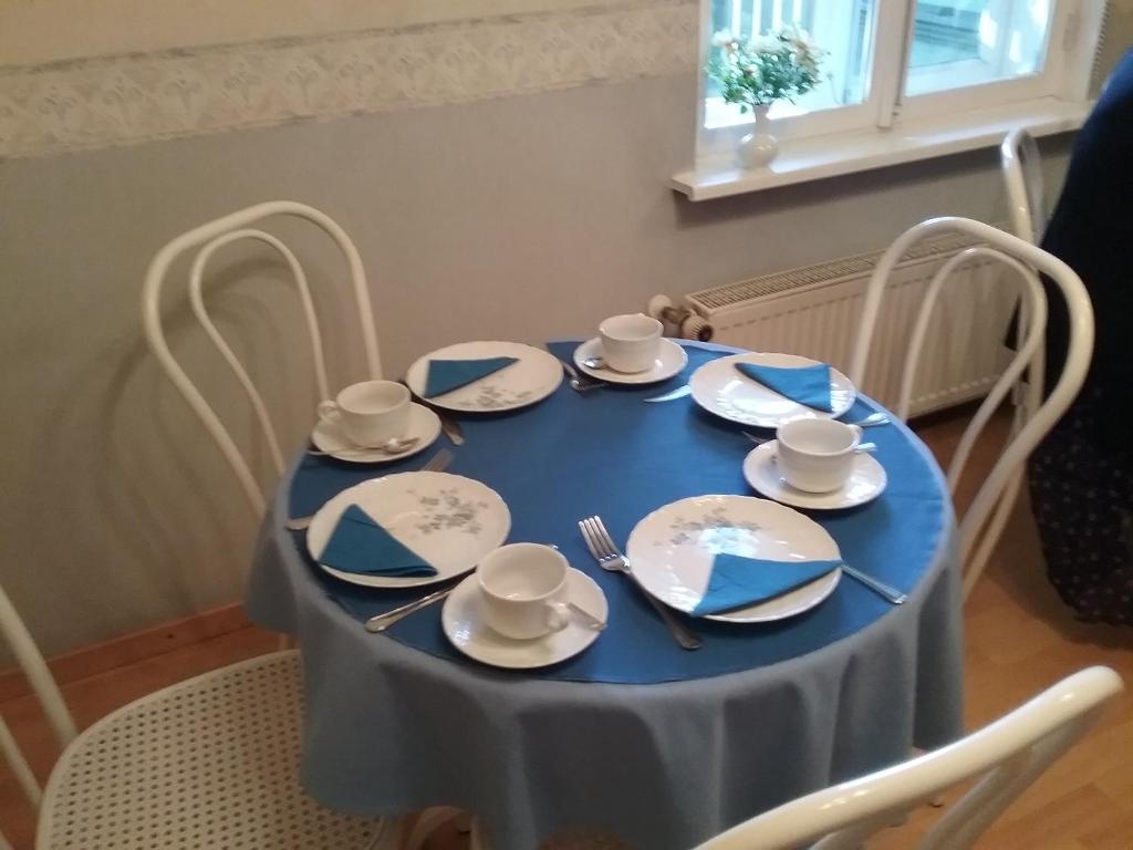 a blue table with plates and silverware on it at Poska Villa Guesthouse in Tallinn