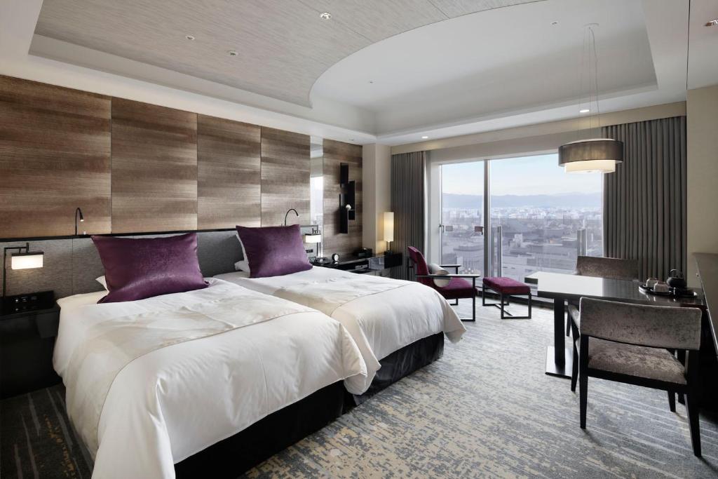 ein Hotelzimmer mit einem großen Bett und einem Schreibtisch in der Unterkunft Hotel Granvia Kyoto in Kyoto