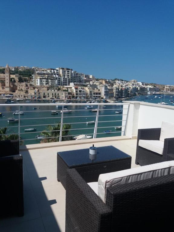 a balcony with a view of the water at Blue Skies Penthouse in Marsaskala