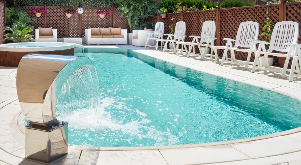 una piscina con sedie e fontana di Hotel Bellerofonte a Rimini