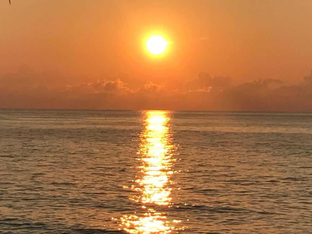 una puesta de sol sobre el océano con el sol en el cielo en Viva Sai, en San Andrés