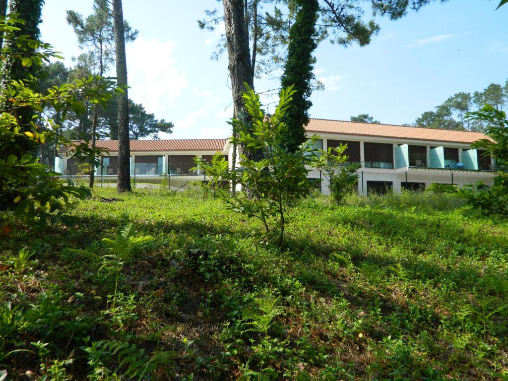 a house in the middle of a field with trees at Hotel Alén do Mar in Finisterre