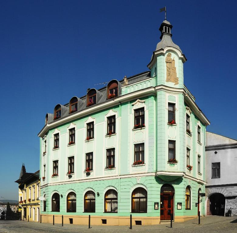 un gran edificio con una torre de reloj encima en Hotel Růžek en Hranice
