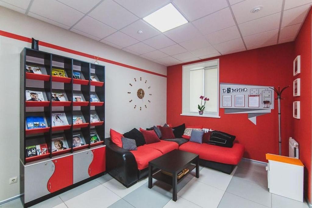 コヴロフにあるDomino Hostelの赤い壁のリビングルーム(赤いソファ付)
