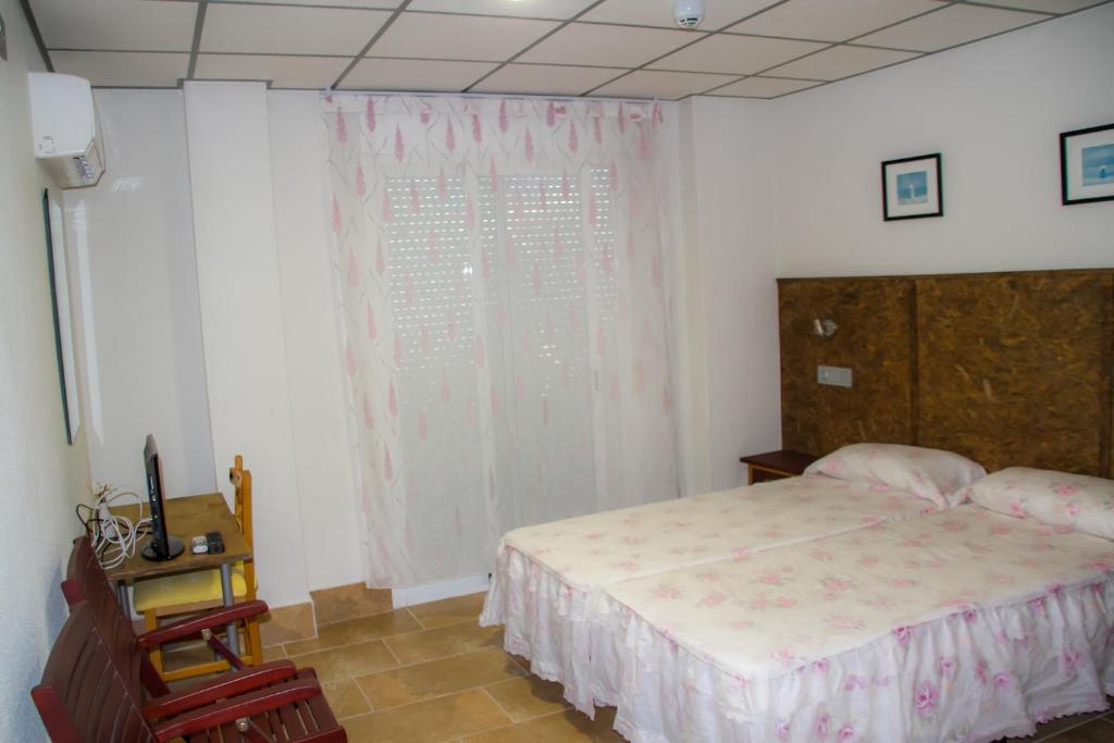 a bedroom with a large bed and a window at Pensión Trinidad in Guardamar del Segura